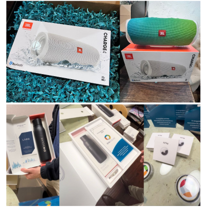 Collage of JBL speakers and OnSolve gift items, including a LARQ bottle kit and boxed Apple AirTags displayed on a table.